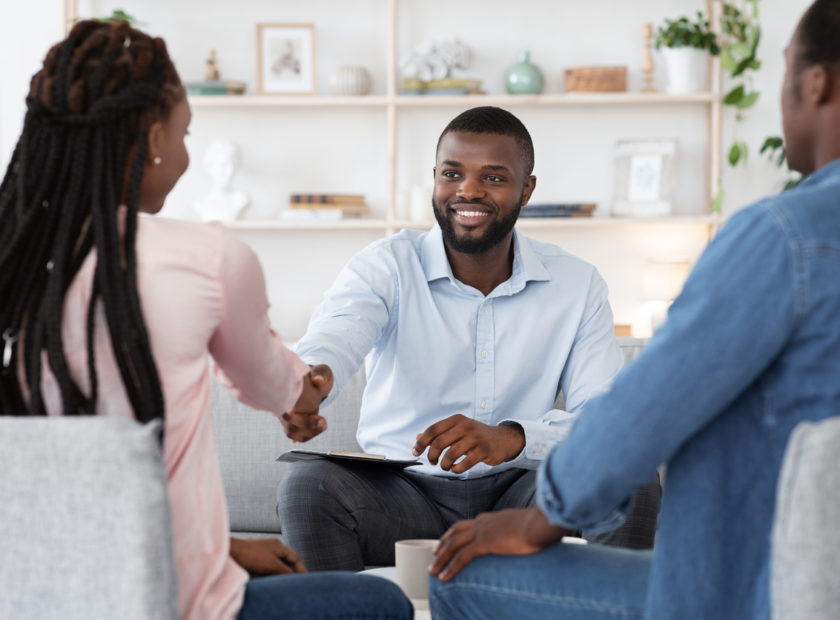Family Counselor Shaking Hands With Happy Black Couple After Successful Therapy
