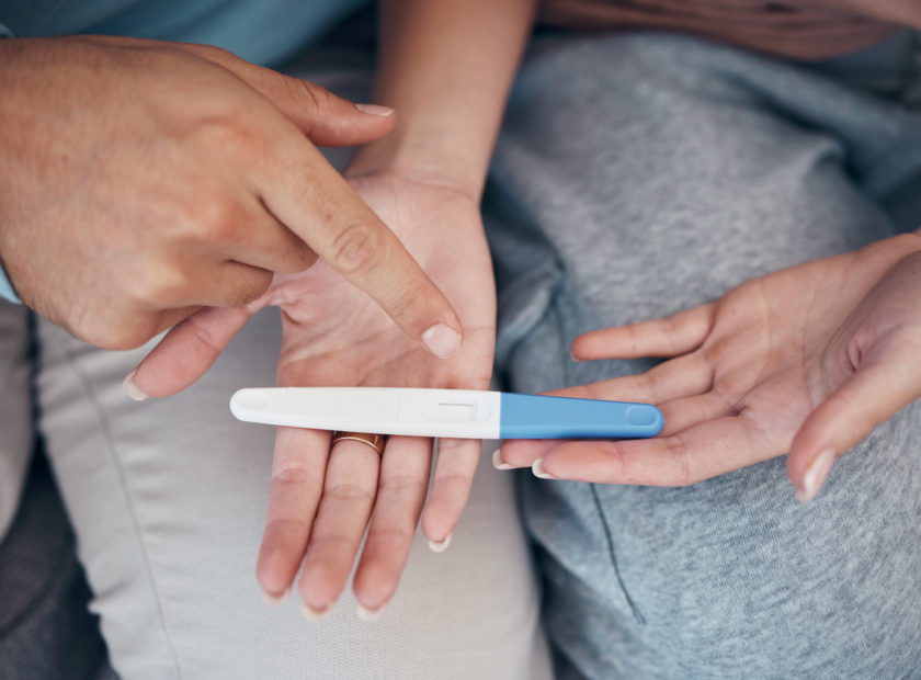 Hands, couple and closeup of pregnancy test, results and waiting for news together in home. Top view, kit and pregnant woman and man family planning for future maternity, ivf fertility and support