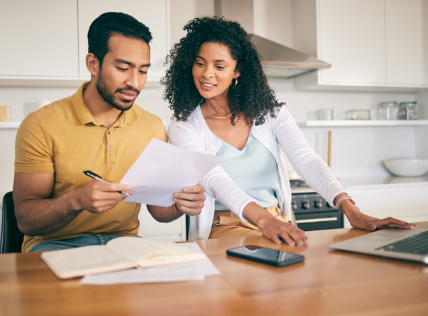 Couple, insurance paperwork and budget planning with laptop, bills and finance with taxes and mortgage. Financial documents, payment and loan with policy, audit and review with asset management